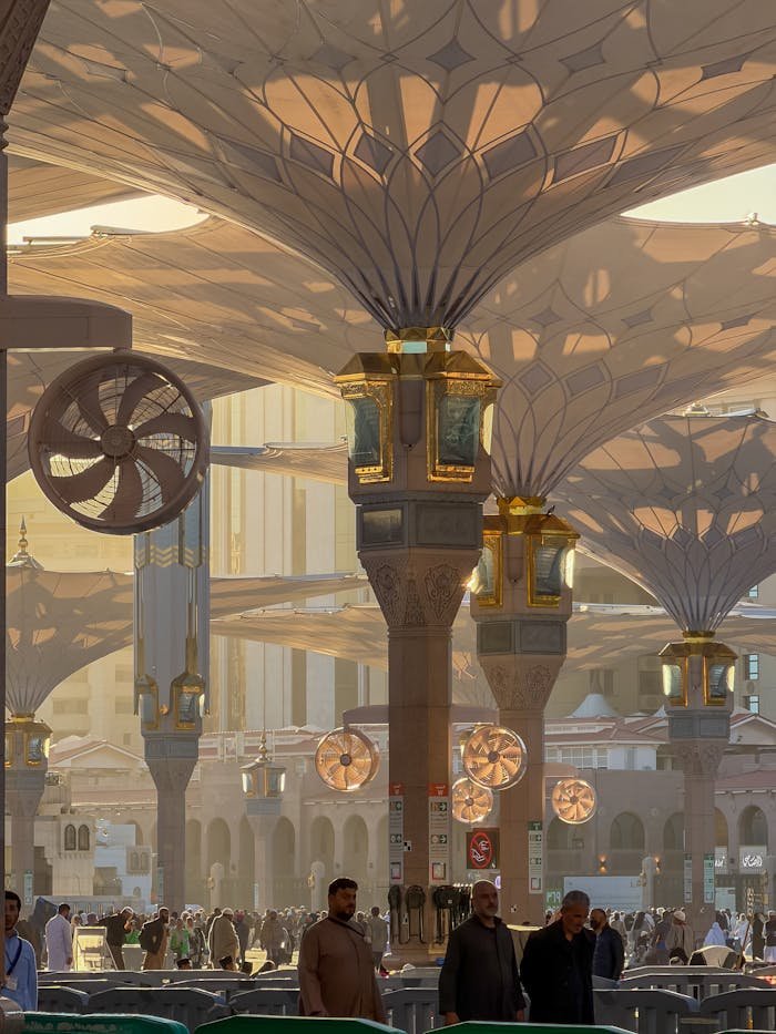 People gather under the iconic umbrellas at Al-Masjid an-Nabawi in Madinah, Saudi Arabia.
